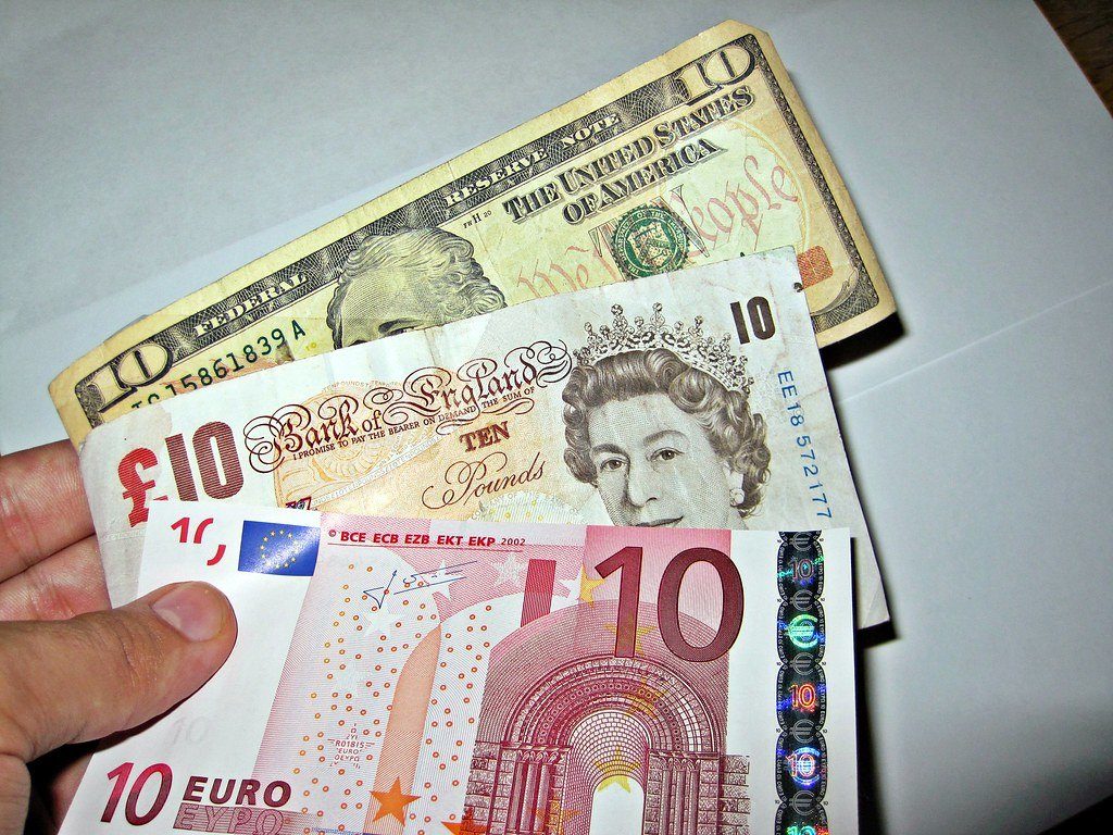 Banknotes in several currencies held in one hand