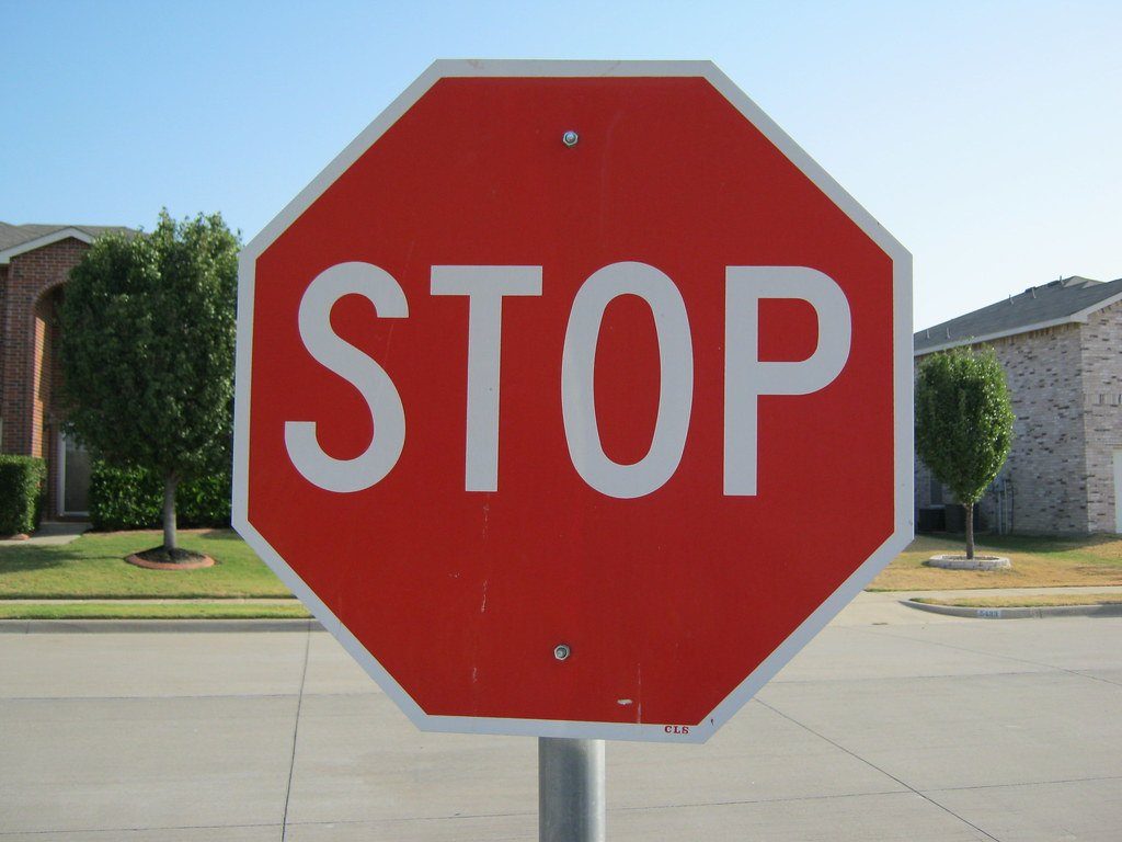 A red stop sign against a blue sky
