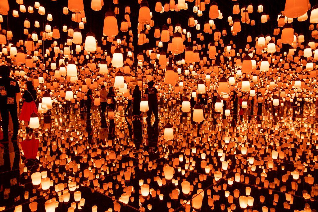 An immersive digital art installation filled with glowing lanterns